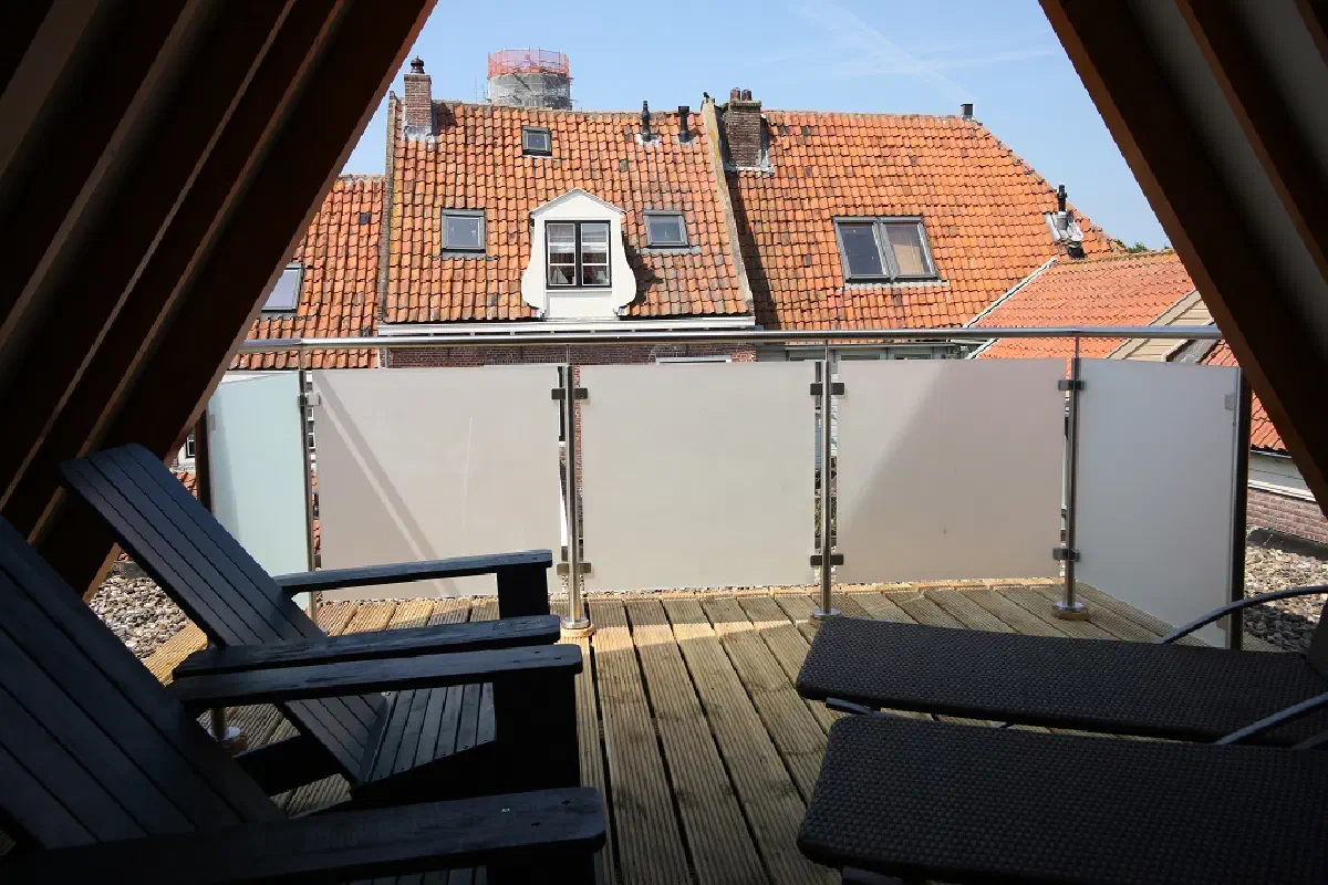 Loggia met loungestoelen en uitzicht over de daken